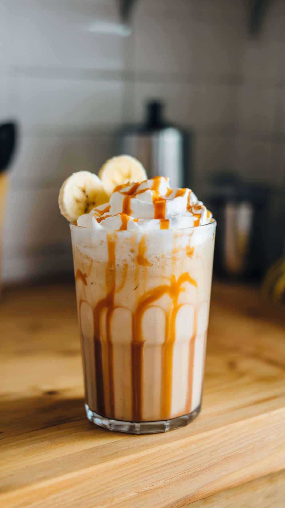 A delicious banana caramel frappe with whipped cream and caramel drizzle.