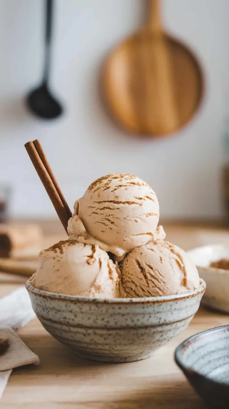 A bowl of spiced chai coffee ice cream with cinnamon sticks.