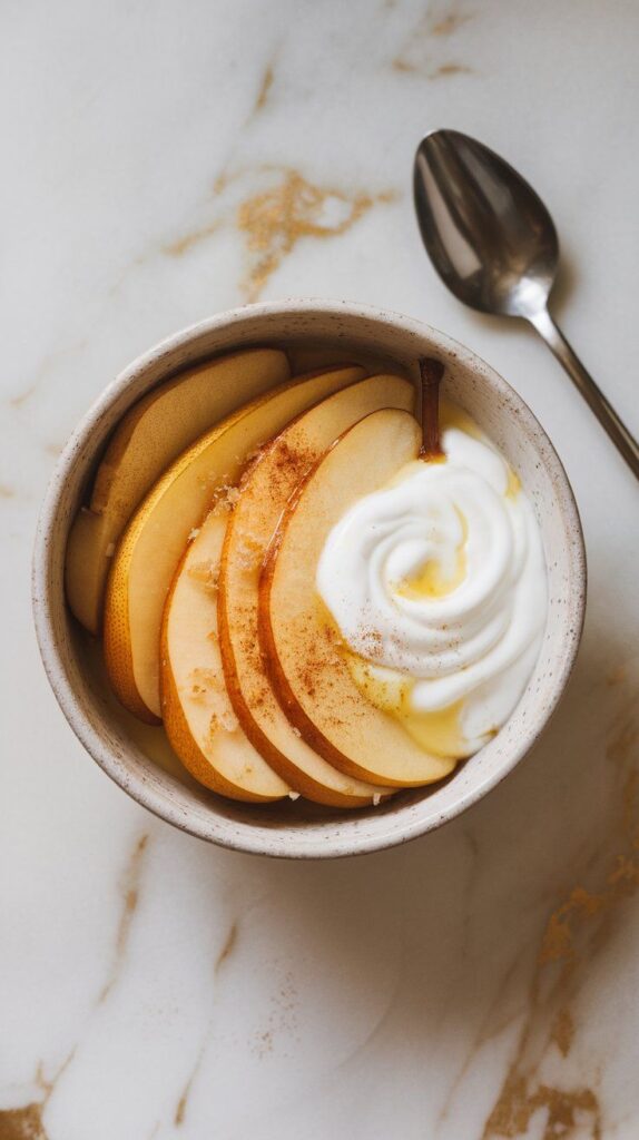 golden pear slices layered on top of creamy swirled Greek yogurt, steam lightly rising off the fruit