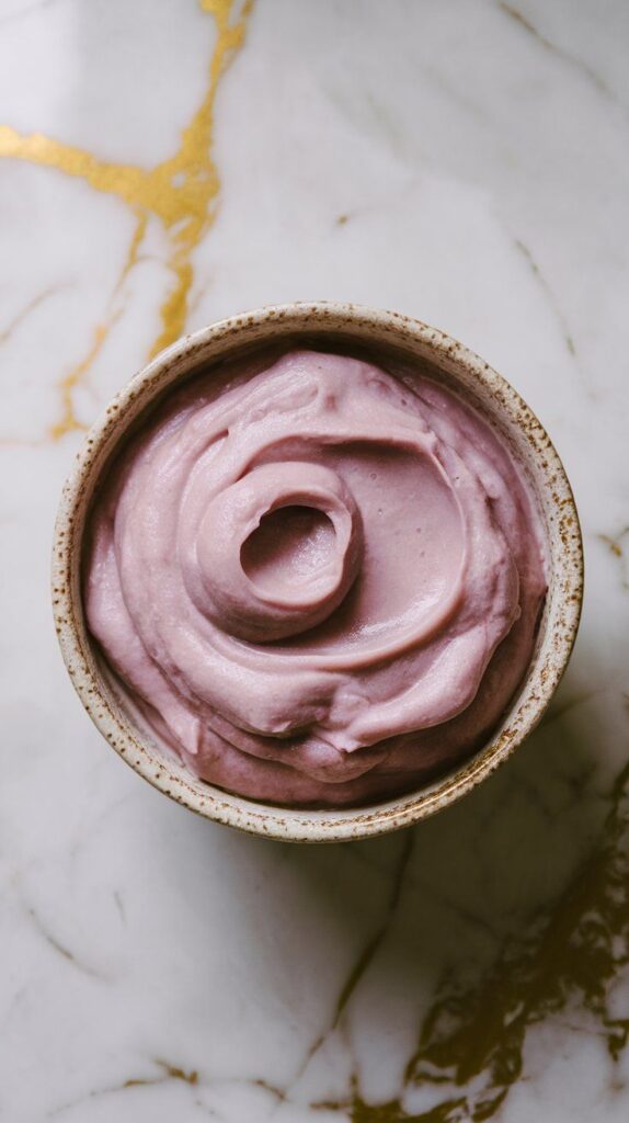 creamy mashed ube in a small ceramic bowl, smooth and thick with a deep purple color