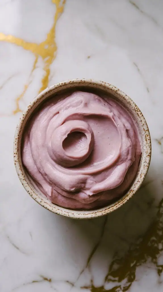 creamy mashed ube in a small ceramic bowl, smooth and thick with a deep purple color